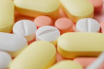 Close-up of assorted yellow, white, and pink pills