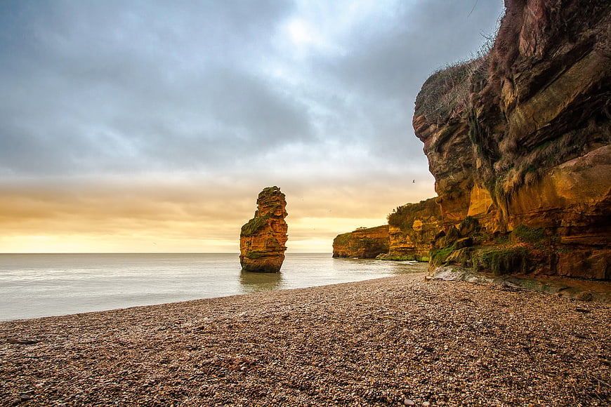 Dramatic coastal landscape with sea stack and cliffs at sunset