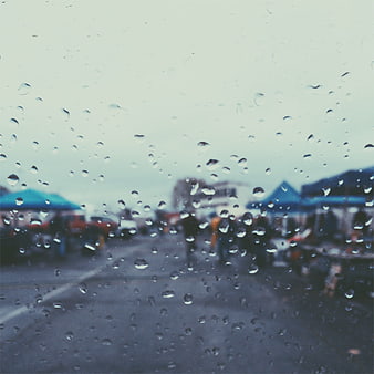 Raindrops on Window with Blurred Outdoor Market Background