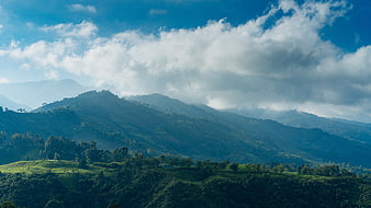Majestic Green Hills and Mountains Under Blue Sky