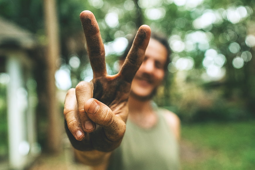 Man Making Peace Sign with Dirty Hand Outdoors