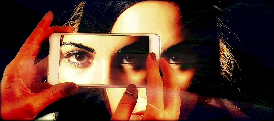 Woman holding smartphone with double exposure artistic effect