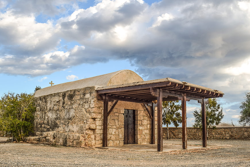 Old Stone Chapel with Wooden Porch Under Cloudy Sky