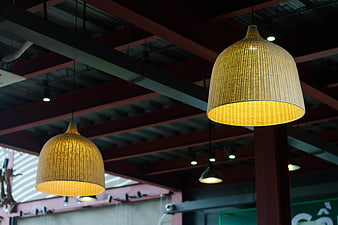 Woven rattan pendant lights hanging from industrial ceiling