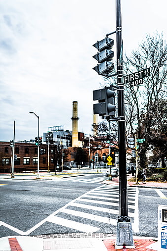 Urban street corner with traffic lights and industrial smokestacks