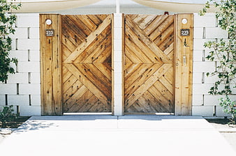 Modern wooden chevron gates with white block wall