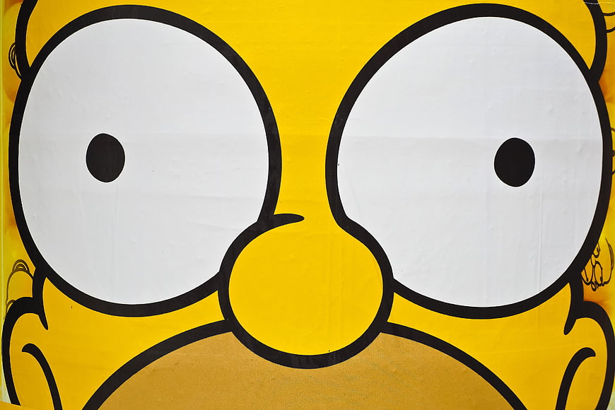 Close-up of yellow cartoon character face with large white eyes