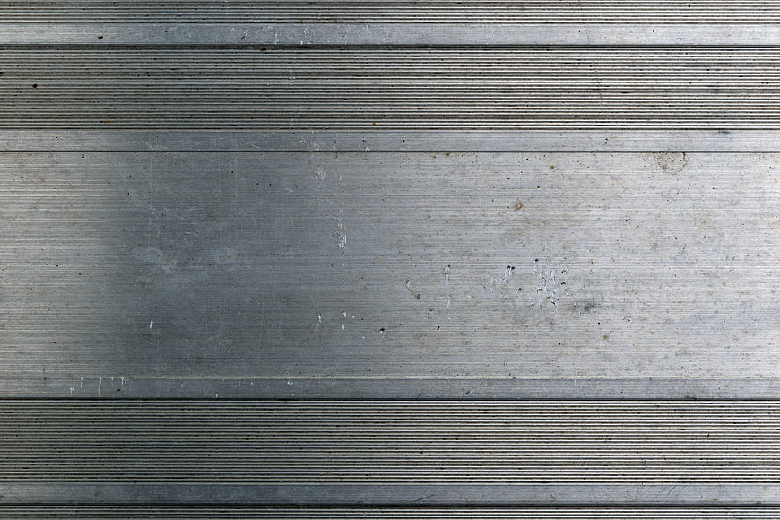 Textured brushed metal surface with industrial grooves and scratches