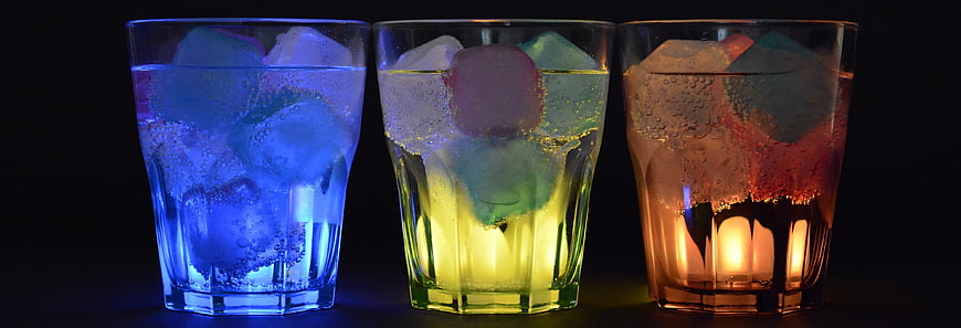 Three Colorful Glowing Drinks with Ice Cubes
