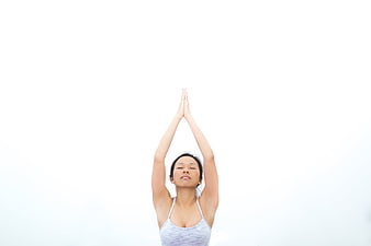 Woman meditating with hands raised in prayer position