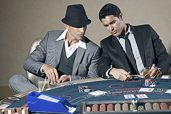 Two men in suits playing blackjack at a casino table