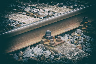 Close-up of rusty railway track with gravel and concrete sleepers