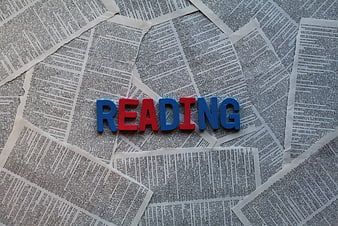 Reading spelled with colorful letters on newspaper background