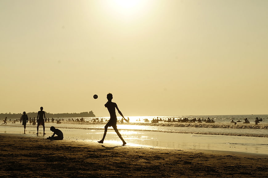 Silhouette of Man Playing Soccer on Beach at Sunset