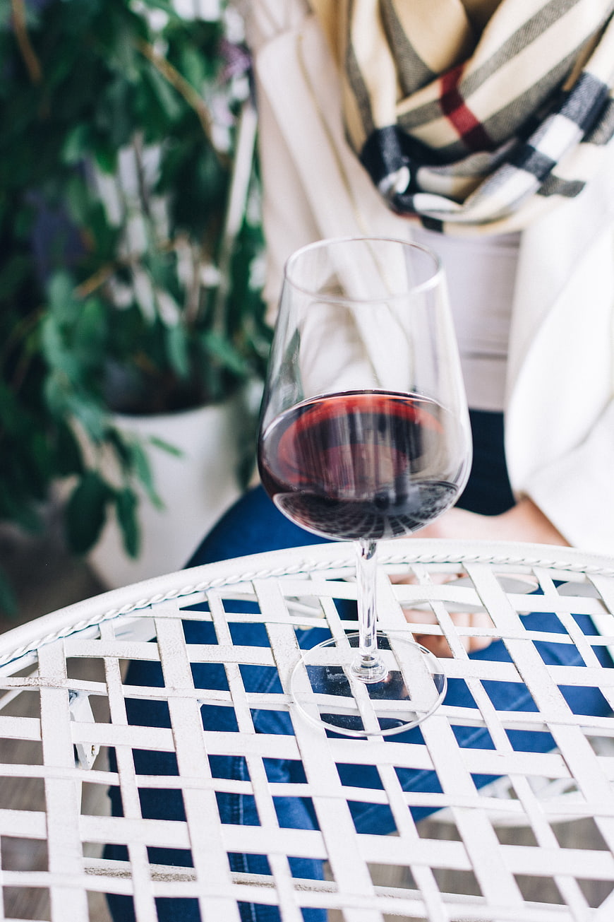 Glass of red wine on white lattice table