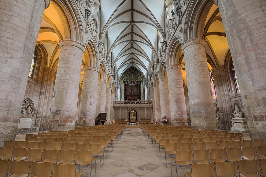 Interior of Gothic Cathedral with Stone Columns and Wooden Chairs