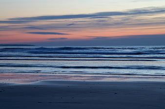 Serene Sunset Beach with Pink and Blue Sky Reflections