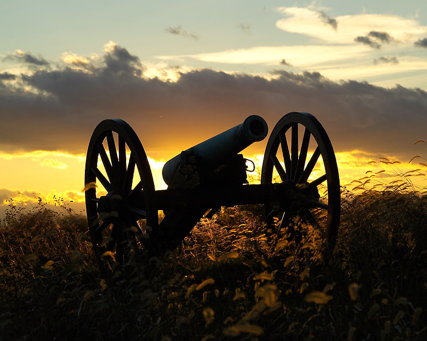 Silhouette of Civil War Cannon in Field at Sunset