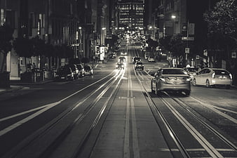 Black and white night city street with cable car tracks