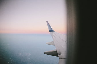 Airplane Wing View at Sunset Over Clouds