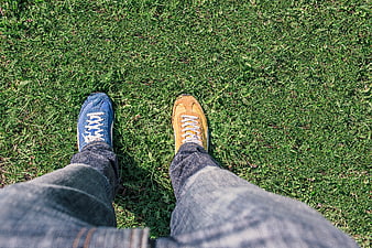 Mismatched Sneakers on Grass: Blue and Yellow Shoes POV
