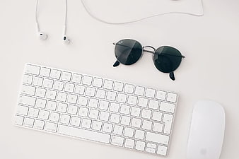 Minimalist White Desk Setup with Keyboard, Mouse, and Sunglasses