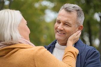 Senior couple sharing tender moment outdoors in autumn