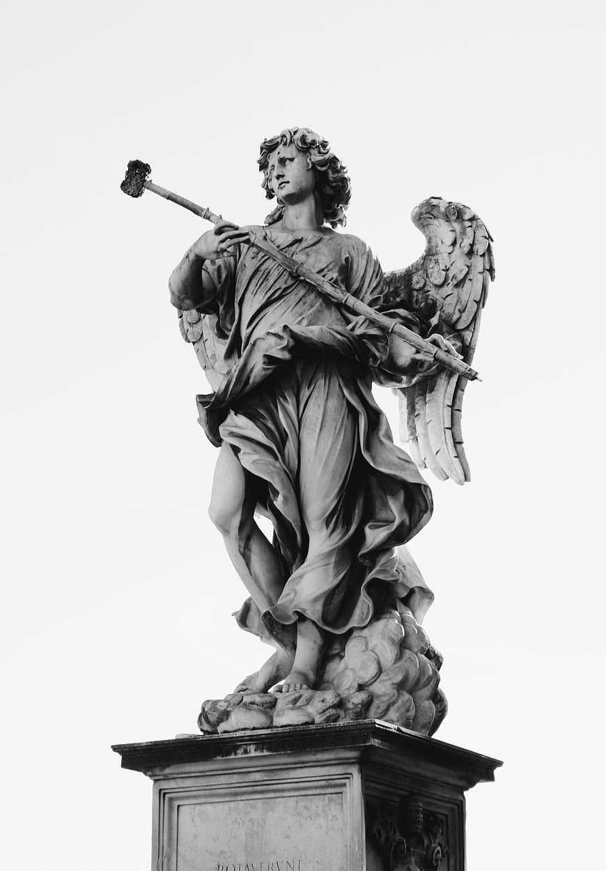 Black and white photo of a baroque angel statue holding a staff