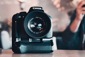 Black Canon DSLR Camera on Wooden Table with Blurred Background