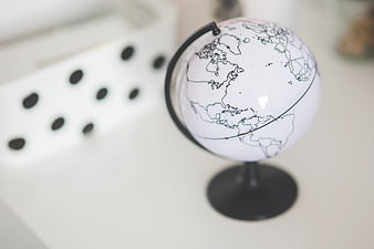 Minimalist white globe on a desk with blurred background