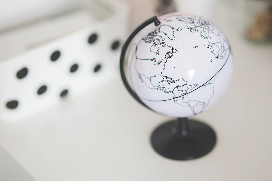 Minimalist white globe on a desk with blurred background