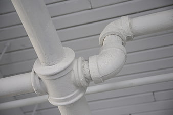 Close-up of white industrial pipes and plumbing fittings
