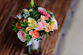 Overhead view of colorful floral bouquet with succulents on wood