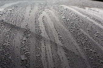 Close-up of water droplets on a wet dark surface