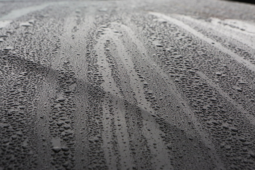 Close-up of water droplets on a wet dark surface