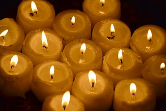 Close-up of burning yellow votive candles in the dark