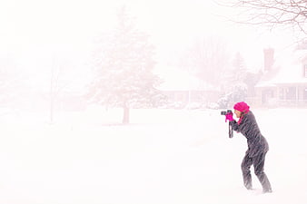 Woman in Pink Hijab Photographing in Heavy Snowstorm