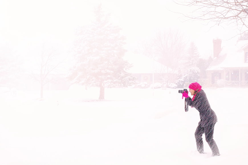 Woman in Pink Hijab Photographing in Heavy Snowstorm