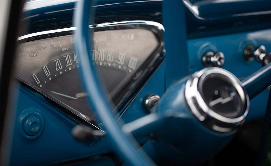 Close-up of vintage blue car dashboard and steering wheel