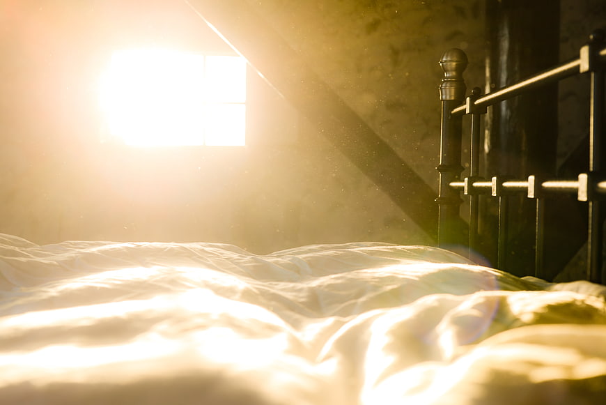 Sunlit Bedroom Interior with Morning Light and Dust Motes