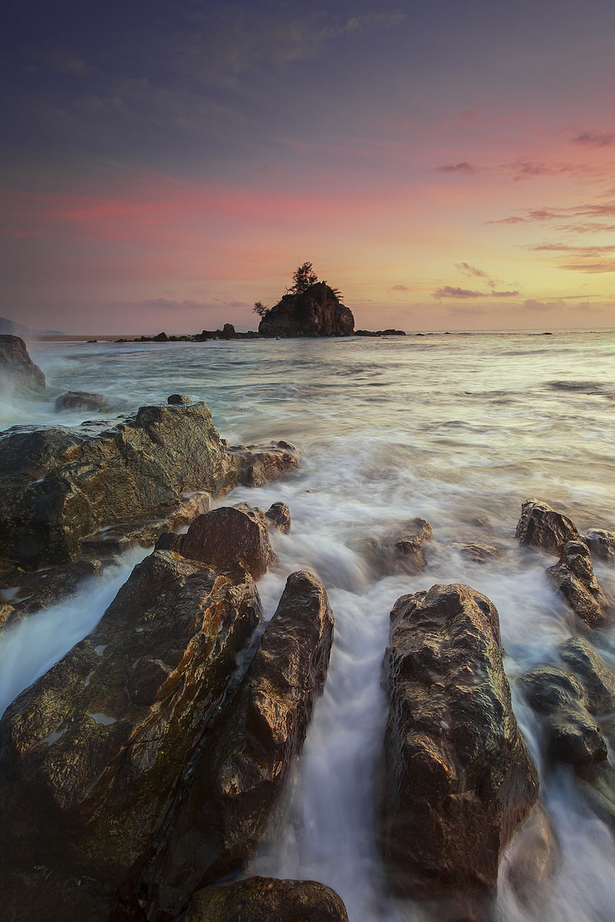 Long Exposure Sunset Over Rocky Coastline with Silhouetted Island