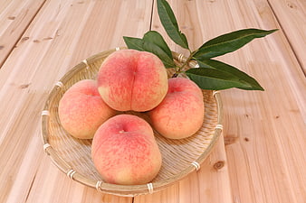 Fresh Peaches In Woven Basket On Wooden Table