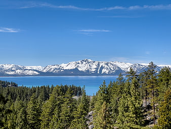 Scenic View of Lake Tahoe with Snow-Capped Mountains and Pine Forest