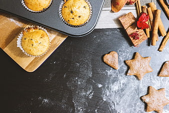 Flat lay of baked muffins and gingerbread cookies with cinnamon