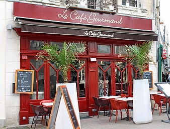 Red French Cafe Exterior with Outdoor Seating and Menu