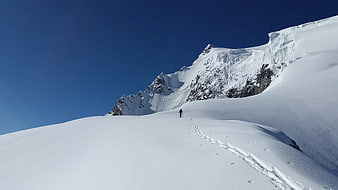 Lone Hiker Walking on Snowy Mountain Ridge