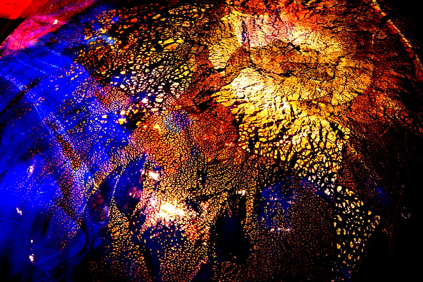 Abstract multicolor glass texture with blue, red, and gold patterns