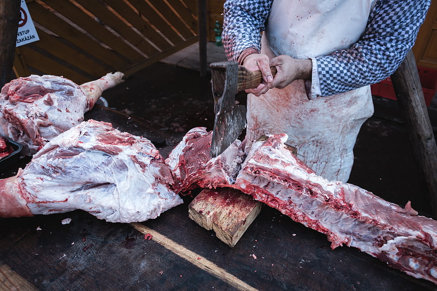 Butcher Chopping Large Meat Cuts with Axe