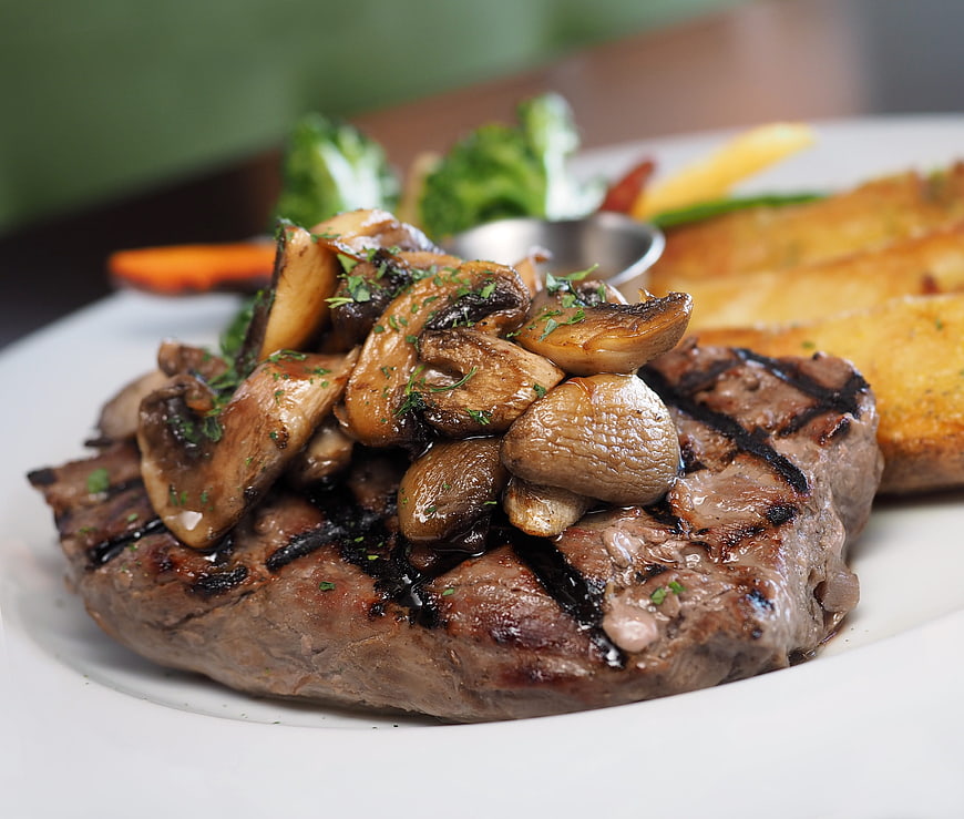 Grilled Steak with Mushrooms and Potatoes on White Plate