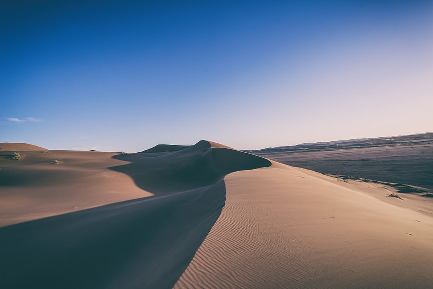 Sweeping Sand Dunes Under Clear Blue Sky